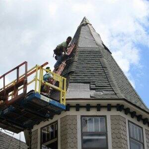 roofer installing asphalt shingle roof